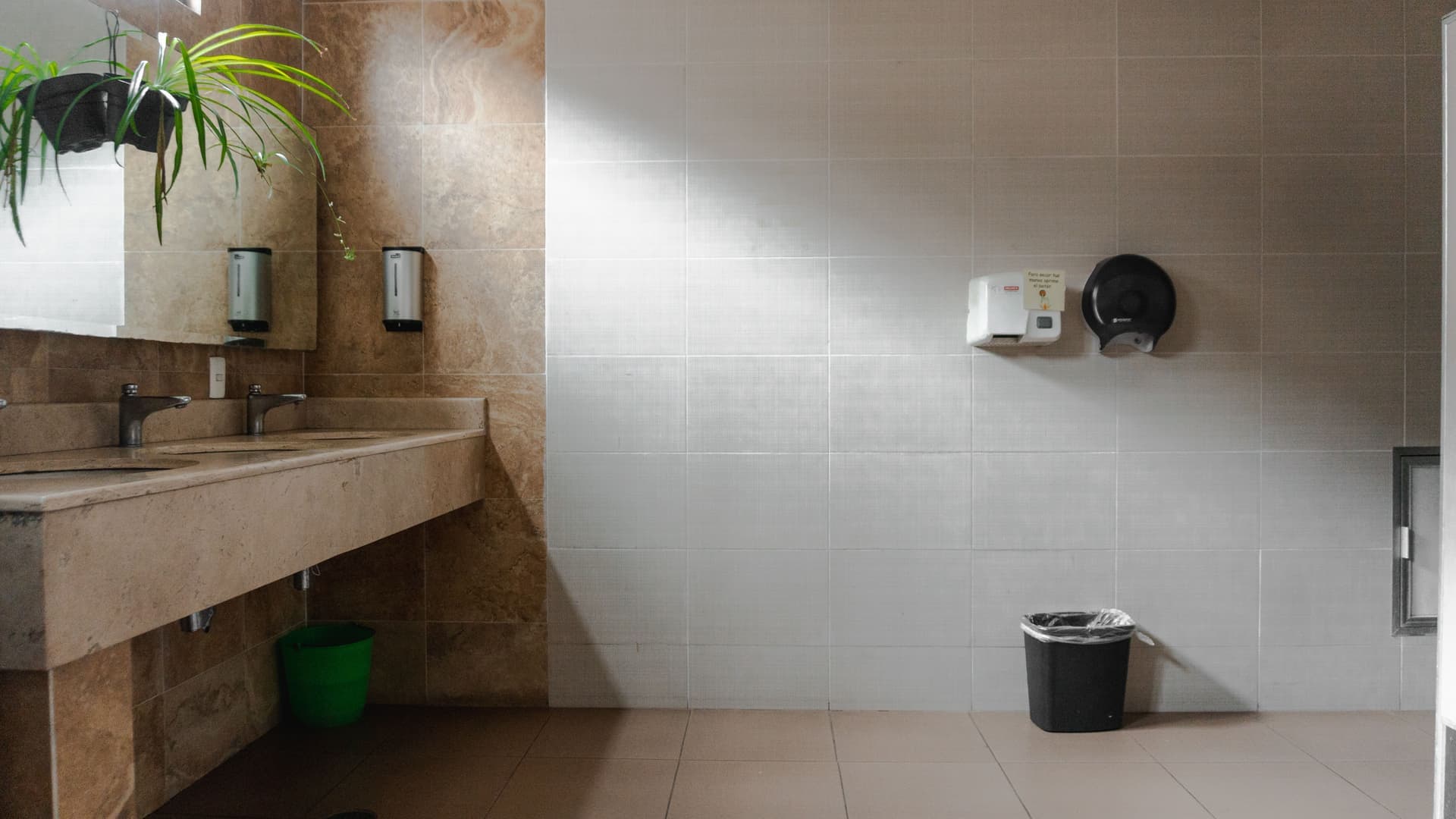 A hair dryer resting on a bathroom counter beside folded towels in natural light