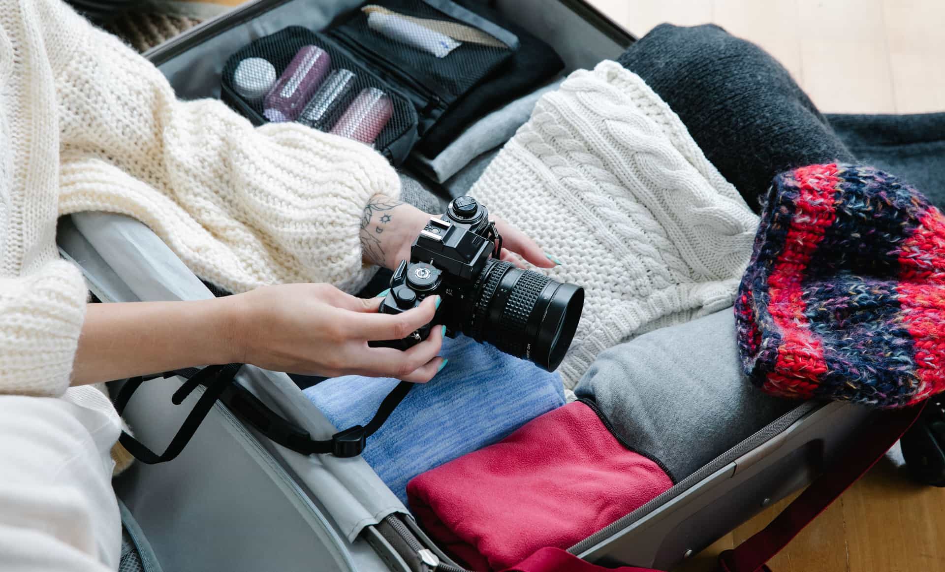 An open suitcase with toiletries and a travel plug adapter