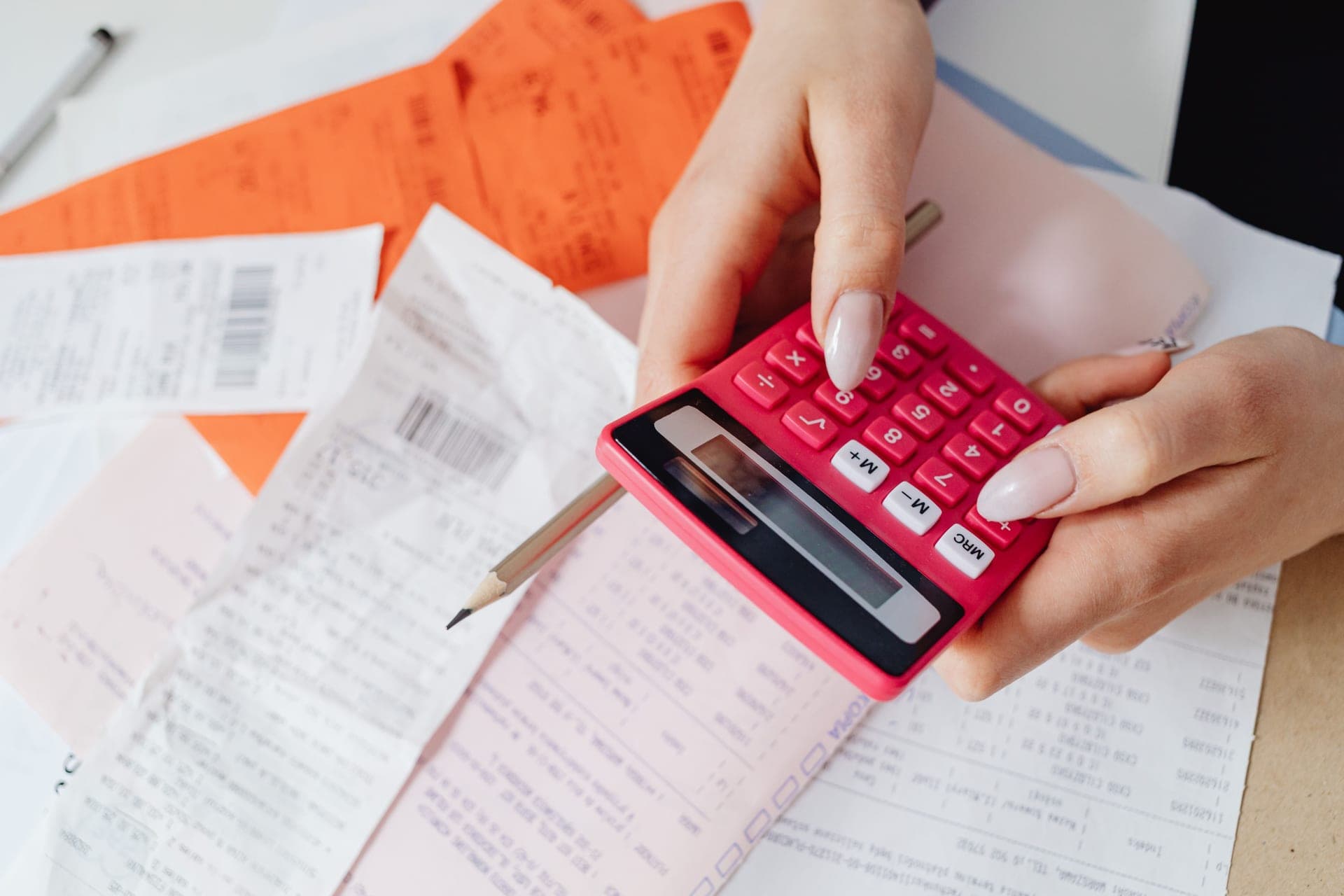 A calculator and receipts on a desk in daylight